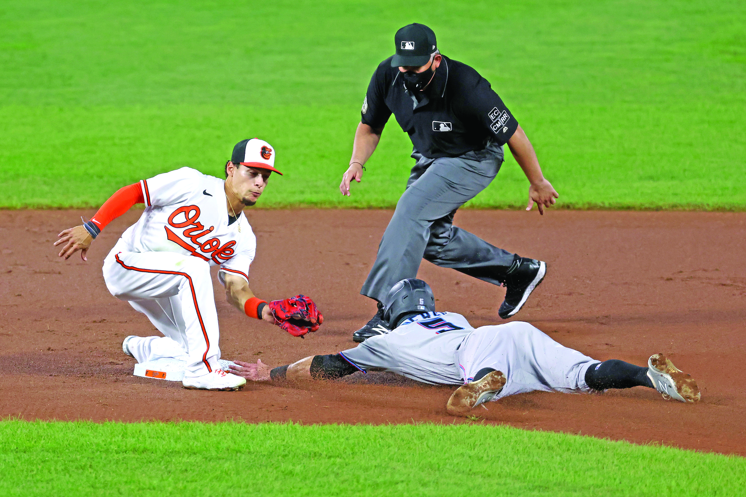 BALTIMORE, MARYLAND - AUGUST 04: Jon Berti #5 of the Miami Marlins steals second base as shortstop Andrew Velazquez #13 of the Baltimore Orioles applies the late tag in the first inning at Oriole Park at Camden Yards on August 04, 2020 in Baltimore, Maryland.   Rob Carr/Getty Images/AFP