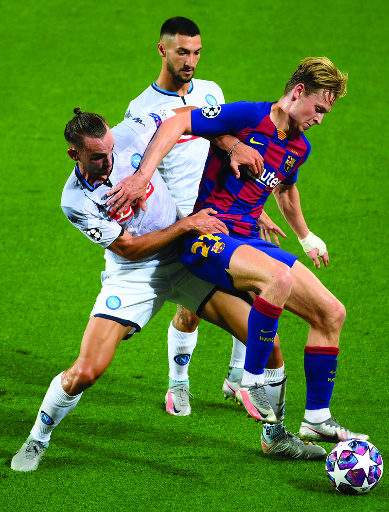 Napoli's Spanish defender Fabian Ruiz (L) fights for the ball with Barcelona's Dutch midfielder Frenkie De Jong (R) during the UEFA Champions League round of 16 second leg football match between FC Barcelona and Napoli at the Camp Nou stadium in Barcelona on August 8, 2020. (Photo by LLUIS GENE / AFP)