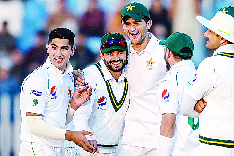 (FILES) This file photo taken on February 7, 2020 shows Pakistan's Azhar Ali (2nd L) celebrating with teammates Naseem Shah (L) and Shaheen Shah Afridi (3rd L) after the dismissal of Bangladesh's Mohammad Mithun (unseen) during the first day of the first cricket Test match between Pakistan and Bangladesh at the Rawalpindi Cricket Stadium in Rawalpindi. - To understand the culture of fast bowling in Pakistan, look no further than Imran Khan, whose rise underlines a tradition where speed is king, and blistering pace is essential for any team. As if to reinforce the point, Pakistan have eight quicks in their 20-man squad for the three-Test series against England, starting on August 5, 2020, ready to unleash their trademark pace and swing. (Photo by AAMIR QURESHI / AFP)