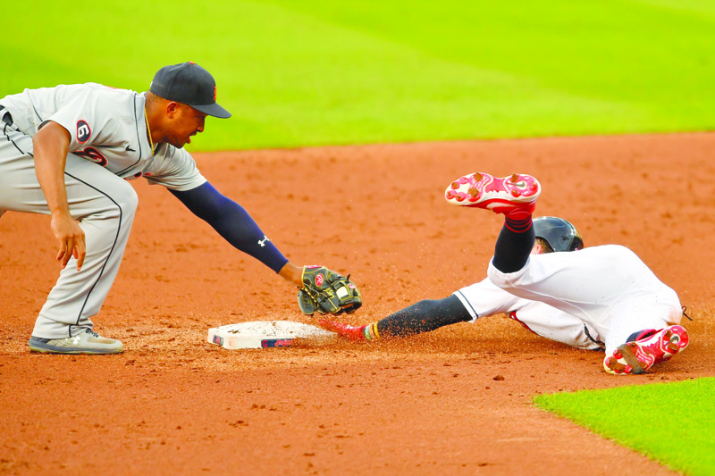 CLEVELAND, OHIO - AUGUST 21: Second baseman Jonathan Schoop #8 of the Detroit Tigers tries to tag Tyler Naquin #30 of the Cleveland Indians during the first inning at Progressive Field on August 21, 2020 in Cleveland, Ohio.   Jason Miller/Getty Images/AFP