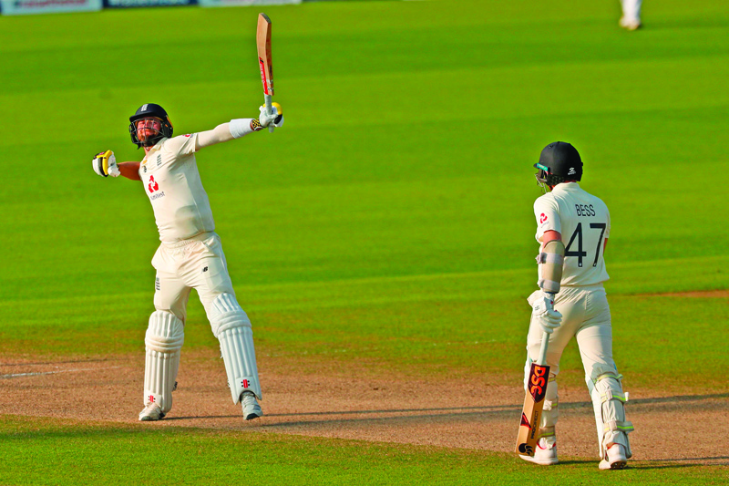 England's Chris Woakes (L) celebrates after hitting the winning runs during play on the fourth day of the first Test cricket match between England and Pakistan at Old Trafford in Manchester, north-west England on August 8, 2020. - England beat Pakistan by three wickets in 1st Test thriller. (Photo by LEE SMITH / POOL / AFP) / RESTRICTED TO EDITORIAL USE. NO ASSOCIATION WITH DIRECT COMPETITOR OF SPONSOR, PARTNER, OR SUPPLIER OF THE ECB
