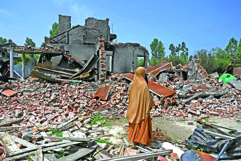 TOPSHOT - In this picture taken on July 30, 2020, a woman inspects the rubbles of the houses of her relatives that where blasted by mortars fired by Indian soldiers during a firefight with rebels, at Sopore north of Srinagar. - The year-long clampdown in Indian-administered Kashmir imposed to tighten New Delhi's grip on the disputed region has shattered its economy and deepened the desperation of its people. The Muslim-majority Himalayan territory, scarred by conflict for decades, is a flashpoint between bitter nuclear-armed rivals India and Pakistan, which control parts of it but claim it in full. (Photo by TAUSEEF MUSTAFA / AFP) / TO GO WITH 'India-Kashmir-conflict-politics',STORY by Parvaiz BUKHARI