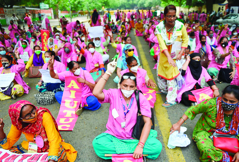 Accredited Social Health Activist (ASHA) shout slogans during a protest to draw attention to their plight of underpayment and lack of protection from the COVID-19 coronavirus infection, in New Delhi on August 9, 2020. (Photo by Money SHARMA / AFP)