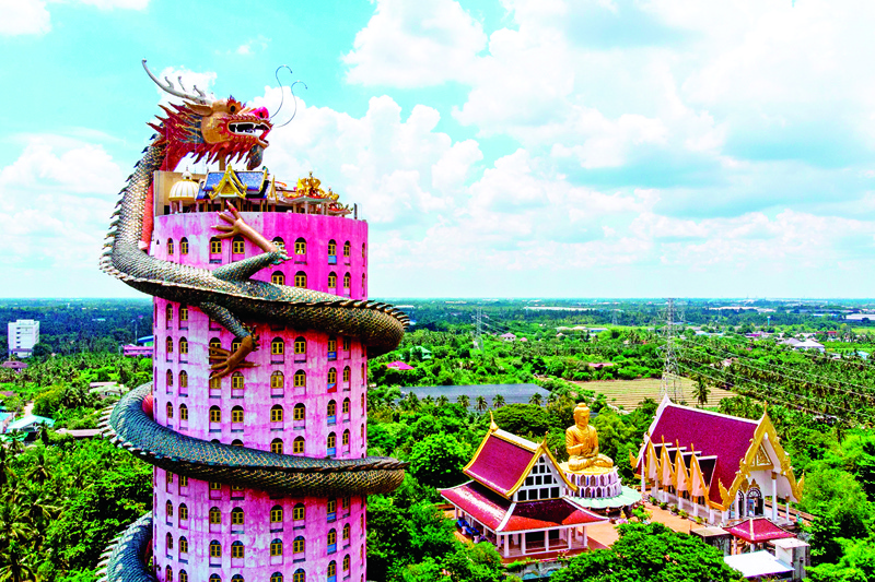TOPSHOT - An aerial view taken on September 11, 2020 shows the Buddhist temple Wat Samphran (Dragon Temple) in Nakhon Pathom, some 40km west of Bangkok. - Wat Samphran is a popular tourist destination with visitors coming to see the huge dragon figure curling around a pink cylindrical building next to the Buddha statues and places of worship of the traditional Buddhist temple complex. (Photo by Mladen ANTONOV / AFP)