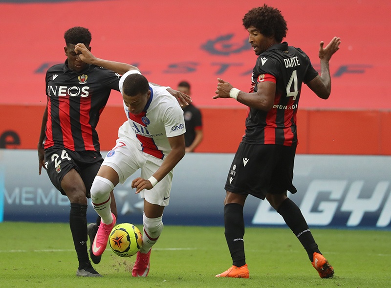 Paris Saint-Germain's French forward Kylian Mbappe (C) vies for the ball with Nice's French defender Andy Pelmard (L) and Nice's Brazilian defender Dante (R) during the French L1 football match between OGC Nice and Paris Saint Germain at The Allianz Riviera Stadium in Nice, south-eastern France on September 20, 2020. (Photo by Valery HACHE / AFP)