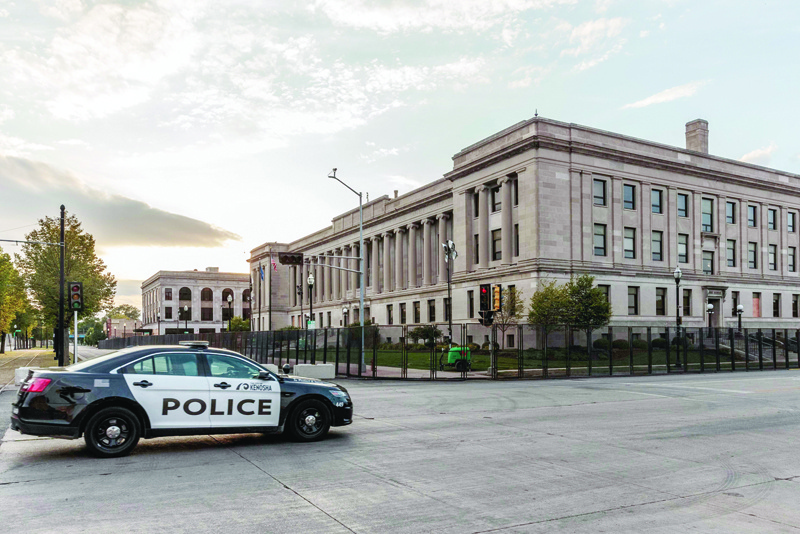 A Kenosha Police car drives past the Kenosha Courthouse surrounded by gates during curfew in Kenosha, Wisconsin on August 31, 2020, following the shooting of Jacob Blake by police. - Donald Trump has no plans to meet with relatives of Jacob Blake, a black man who was shot by police, when the president visits the Wisconsin city where the shooting sparked violent demonstrations, the White House said on August 31. Trump travels to Kenosha, Wisconsin on September 1, defying Democratic leaders there who have reportedly urged him not to visit the city in the wake of the shooting. (Photo by Kerem Yucel / AFP)