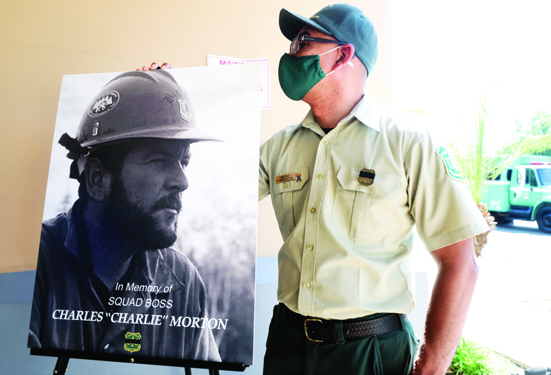 SAN BERNARDINO, CALIFORNIA - SEPTEMBER 25: A photograph of fallen Big Bear Interagency Hotshot Charles Morton, a firefighter who was killed battling the El Dorado wildfire, is displayed at a memorial service for Morton on September 25, 2020 in San Bernardino, California. Morton was a 14-year veteran with the U.S. Forest Service. The El Dorado fire has scorched more than 22,000 acres in Southern California.   Mario Tama/Getty Images/AFP