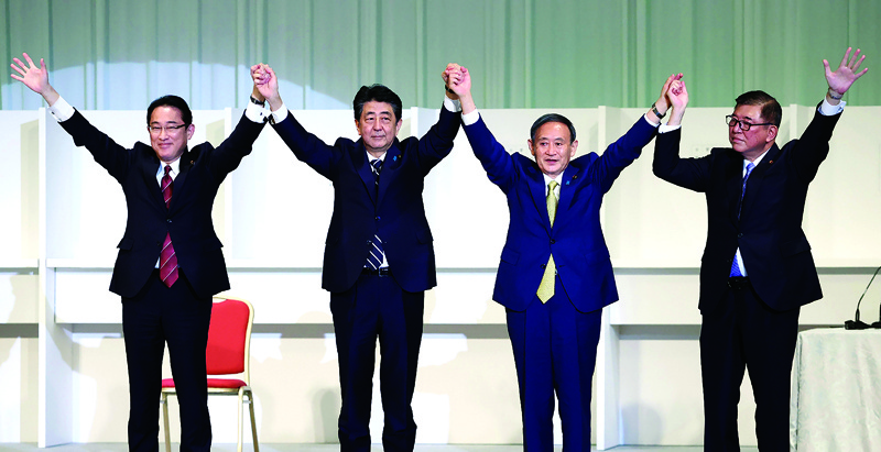 (From L to R) Japan's former foreign minister Fumio Kishida, outgoing Prime Minister Shinzo Abe, newly elected leader of Liberal Democratic Party (LDP) Yoshihide Suga and former defence minister Shigeru Ishiba celebrate after ruling party's leadership election in Tokyo on September 14, 2020. - Japan's ruling party on September 14 elected chief cabinet secretary Yoshihide Suga as its new leader, making him all but certain to replace Shinzo Abe as the country's next prime minister. (Photo by STR / JIJI PRESS / AFP) / Japan OUT
