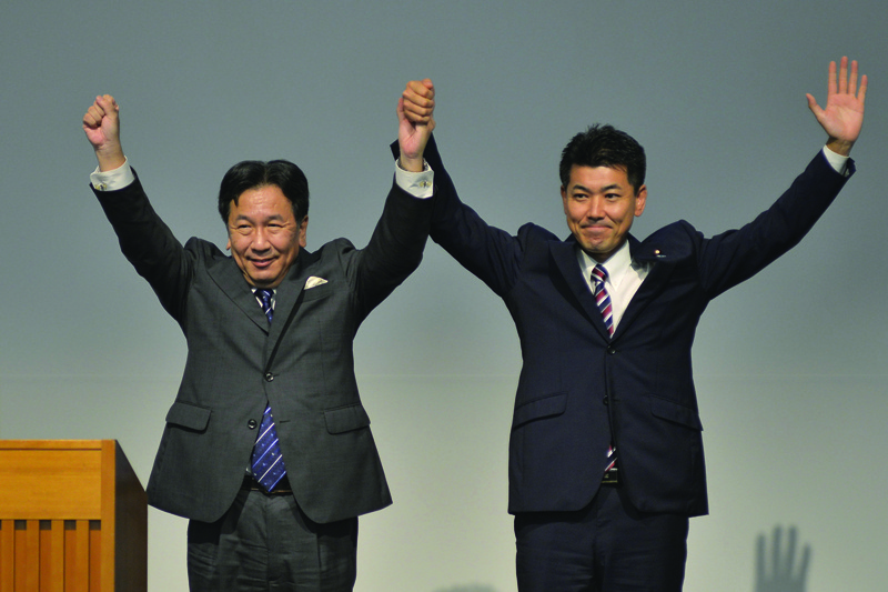 Yukio Edano (L), head of the Constitutional Democratic Party of Japan (CDP), and Kenta Izumi (R), policy chief of the Democratic Party for the People (DPFP), raise their hands following a vote for the leadership of a new main opposition party in Tokyo on September 10, 2020. - Prime Minister Shinzo Abe announced his shock decision to step down on August 28 due to ill health. His ruling LDP will hold an election on September 14 for the party leadership, with a parliamentary vote for prime minister possibly two days later with opposition candidates expecting to stand. (Photo by David MAREUIL / POOL / AFP)