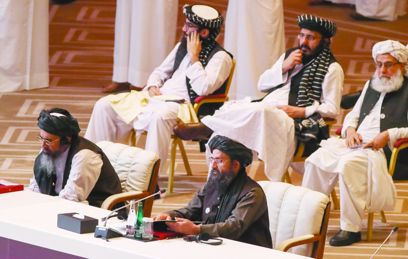 Taliban co-founder Mullah Abdul Ghani Baradar (R, bottom) speaks during the opening session of the peace talks between the Afghan government and the Taliban in the Qatari capital Doha on September 12, 2020. (Photo by KARIM JAAFAR / AFP)