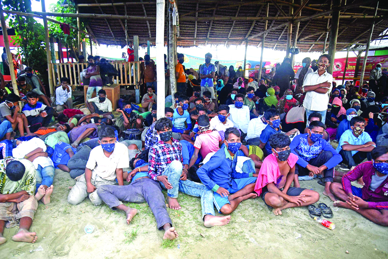 Rohingya migrants look on following their arrival by boat in Lhokseumawe, Aceh on September 7, 2020. - Nearly 300 Rohingya migrants came ashore on Indonesia's Sumatra island early on September 7, authorities said, in what is believed to be the biggest landing of the persecuted Myanmar minority in years. (Photo by Rahmat Mirza / AFP)