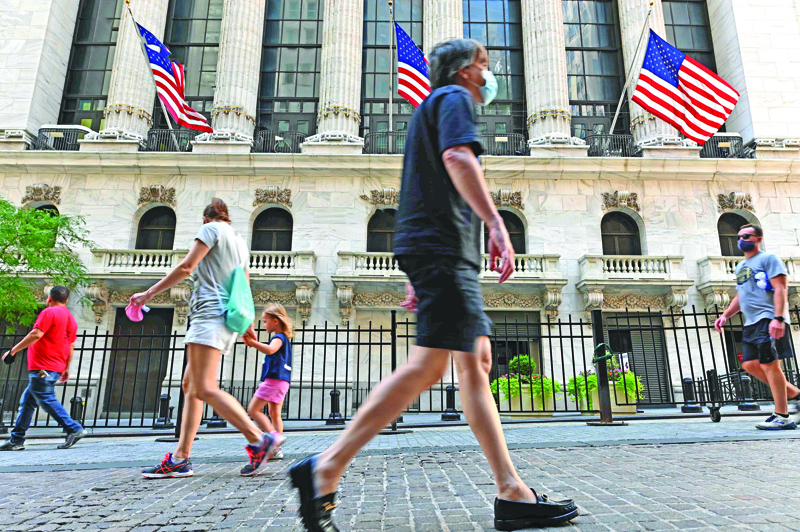 (FILES) In this file photo taken on August 3, 2020 people pass by The New York Stock Exchange (NYSE) at Wall Street in New York City. - Wall Street flexed its muscles on August 28, with the Dow erasing its losses for the year and the S&amp;P and Nasdaq again hitting records as investors shrugged off the ongoing coronavirus crisis, while markets elsewhere saw more moderate trading. (Photo by Angela Weiss / AFP)