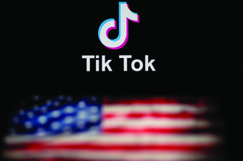 This photo illustration taken on September 14, 2020 shows the logo of the social network application TikTok (top) and a US flag (bottom) shown on the screens of two laptops in Beijing. - US tech giant Microsoft said on September 13 its offer to buy TikTok was rejected, leaving Oracle as the sole remaining bidder ahead of the imminent deadline for the Chinese-owned video app to sell or shut down its US operations. (Photo by NICOLAS ASFOURI / AFP)