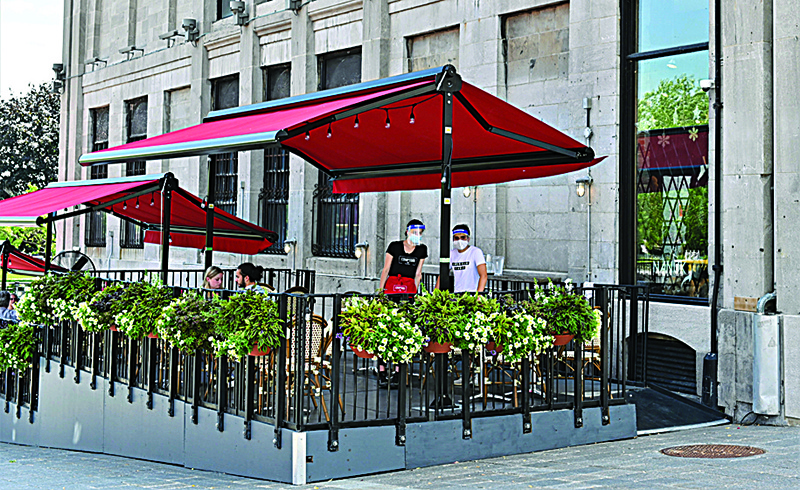MONTREAL: In this file photo, servers wait for clients in a restaurant terrace on the Place Jacques-Cartier, close to the Old-Port in central Montreal, Canada. Canada added 246,000 jobs in August as most coronavirus restrictions eased and businesses reopened, cutting the unemployment rate to 10.2 percent, the national statistics agency said on Friday. —AFP