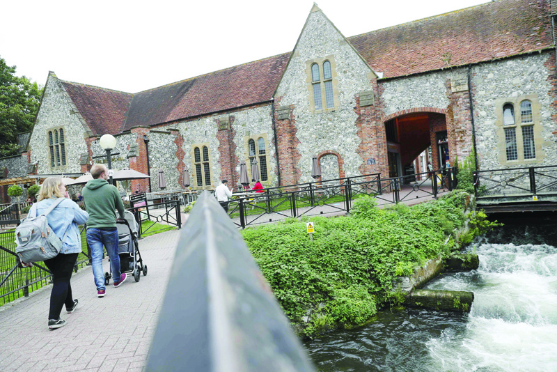 People walk across a footbridge over the River Avon heading toward the Bishop's Mill pub in Salisbury, southern England on September 4, 2020 that was cordoned off following the nerve agent attack on Russian ex-spy Sergei Skripal in March 2018. - A long way from the violent cauldron of Russian politics, the picturesque city of Salisbury is contending with painful memories and a burning sense of injustice as the nerve agent Novichok again hits headlines. The cathedral city in southwest England is all too aware of the chemical weapon's terrifying potency, as survivors of a March 2018 attack follow news of Russian opposition leader Alexei Navalny's fight for life in a German hospital. (Photo by Adrian DENNIS / AFP) / TO GO WITH AFP STORY BY JITENDRA JOSHI