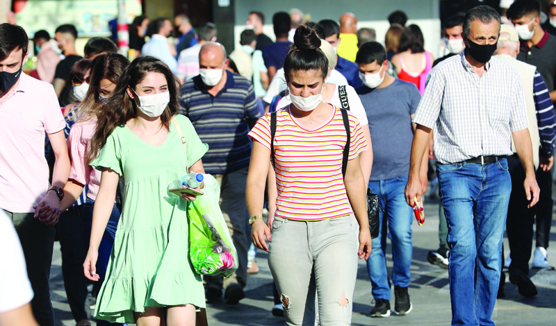 People wear their protective face masks while walking along a street in Ankara on September 18, 2020,  as Turkey reported 1,648 new confirmed cases of the new coronavirus, Covid-19, the highest daily jump in more than a month. (Photo by Adem ALTAN / AFP)