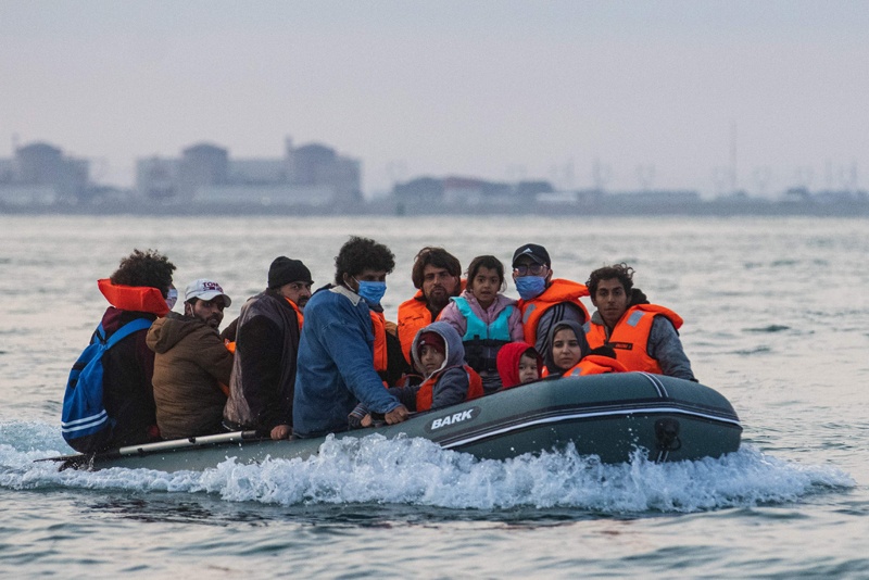 Waleed (C), 29, a Kuwaiti migrant, sits in a dinghy with his brother's family and other migrants as they illegally cross the English Channel from France to Britain on September 11, 2020. - The number of migrants crossing the English Channel -- which is 33,8 km (21 miles) at the closest point in the Straits of Dover --  in small inflatable boats has spiralled over the summer of the 2020. According to authorities in northern France some 6,200 migrants have attempted the crossing between January 1 and August 31, 2020, compared with 2,294 migrants for the whole of 2019. (Photo by Sameer Al-DOUMY / AFP)