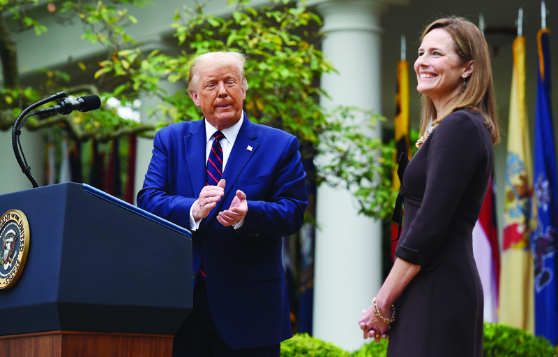 TOPSHOT - US President Donald Trump announces his US Supreme Court nominee, Judge Amy Coney Barrett (R), in the Rose Garden of the White House in Washington, DC on September 26, 2020. - Barrett, if confirmed by the US Senate, will replace Justice Ruth Bader Ginsburg, who died on September 18. (Photo by Olivier DOULIERY / AFP)