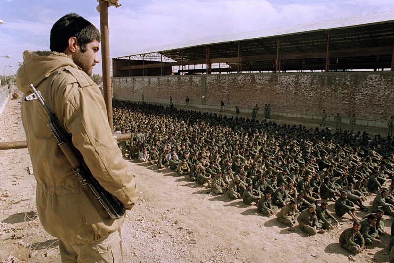 (FILES) In this file photo taken on January 22, 1987, an Iranian soldier guards some Iraqi prisoners of war at a camp in Ahvaz, some 100Km north of Abadan, who were captured in the two-week-old Kerbala-5 offensive. - On September 22, 1980, Iraqi dictator Saddam Hussein sent troops into neighbouring Iran, starting an eight-year war in which hundreds of thousands were killed. (Photo by Eric Feferberg / AFP)