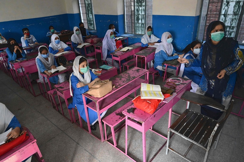 Students wearing facemasks attend a class at a government school in Lahore on September 15, 2020 after the educational institutes were reopened nearly six months after the spread of the Covid-19 coronavirus. (Photo by Arif ALI / AFP)