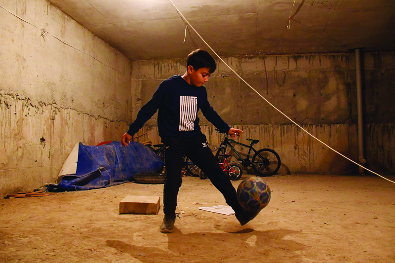 A boy plays with a ball in a building's basement used as a bomb shelter in Nagorny Karabakh's main city of Stepanakert on September 27, 2020. - Fierce fighting between Azerbaijani and Armenian forces raged Monday, claiming a growing number of lives and sparking bellicose rhetoric from regional power Turkey, despite international pleas for a halt in fighting between the longtime enemies. Armenia and Azerbaijan have been locked in a territorial dispute over the ethnic Armenian region of Nagorny Karabakh for decades, with deadly fighting flaring up earlier this year and in 2016. (Photo by Narek Aleksanyan / AFP)
