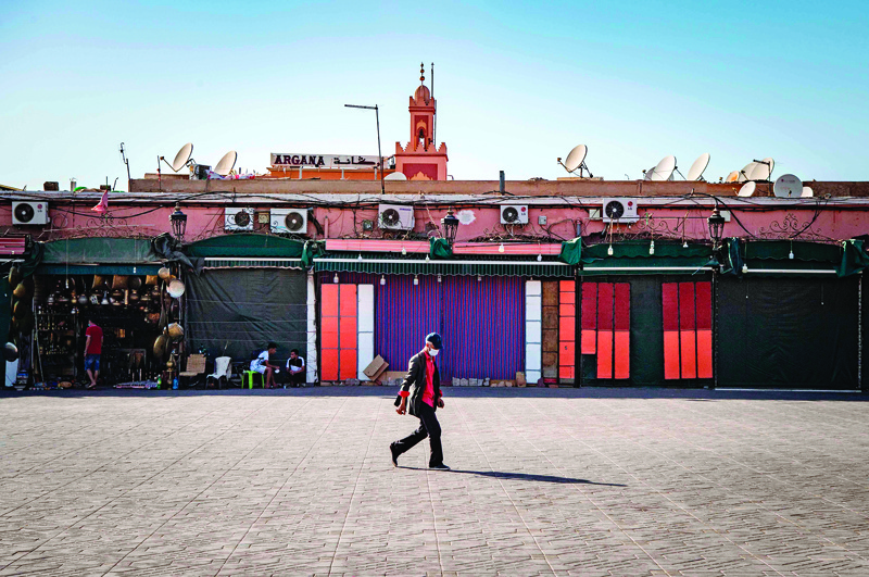 A man walks by mostly-closed stalls at the Jemaa el-Fna square in the Moroccan city of Marrakesh on September 8, 2020, currently empty of its usual crowds due to the COVID-19 pandemic. - Snake charmers, storytellers and crowds of tourists; the legendary Jamaa El Fna square of Morocco's Marrakech is almost as famous for the number of visitors as its colourful performers. But with tough government restrictions imposed to stem the spread of the novel coronavirus, the tourism industry on which Marrakech depends screeched to a halt. (Photo by FADEL SENNA / AFP)