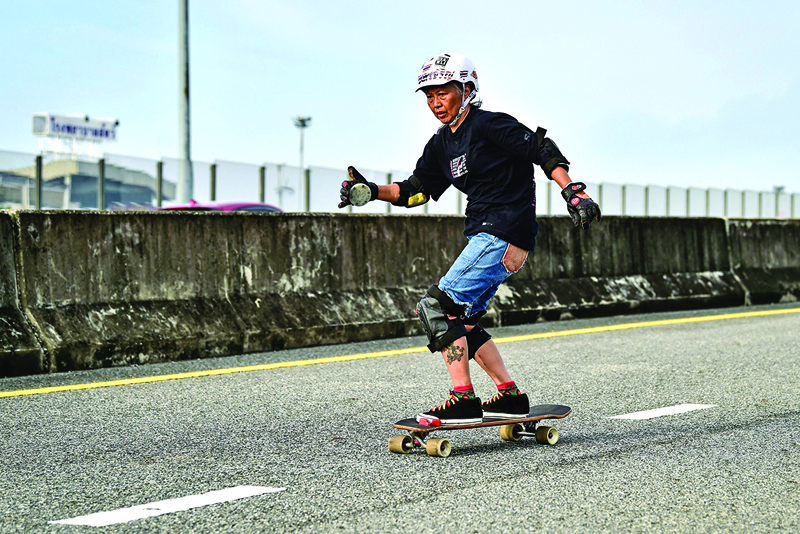 This photo taken on September 9, 2020 shows longboarder and cancer survivor Nongluck Chairuettichai, also known as Jeab, during a practice session on an unfinished highway ramp in Bangkok. - Cruising on an empty Bangkok highway, 63-year-old Jeab says taking up the longboard set her on the road to recovery from breast cancer. (Photo by Lillian SUWANRUMPHA / AFP)
