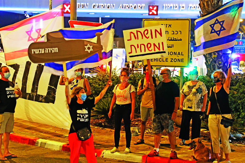 Israeli protesters gather during an anti-government demonstration outside the Ben Gurion Airport near Tel Aviv on September 13, 2020, demanding the resignation of Prime Minister Benjamin Netanyahu over several corruption indictments and his handling of the coronavirus crisis, as he prepares to travel to the US. - The UAE and Bahrain will sign agreements to recognise Israel, on September 15.nUS President Donald Trump and Israeli Prime Minister Benjamin Netanyahu are to sign the Abraham accords -- a reference to the common traditions of Islam, Judaism and Christianity -- at a White House ceremony. (Photo by JACK GUEZ / AFP)