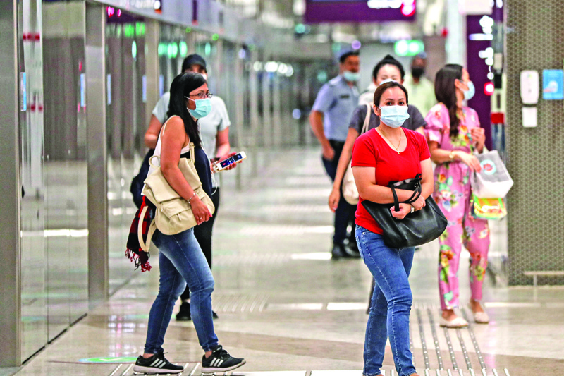 Mask-clad passengers stand along the train platform at a station in Qatar's capital on September 1, 2020, as the Gulf country resumes bus and rail services for the first time since March with reduced capacity due to the COVID-19 coronavirus pandemic. (Photo by KARIM JAAFAR / AFP)