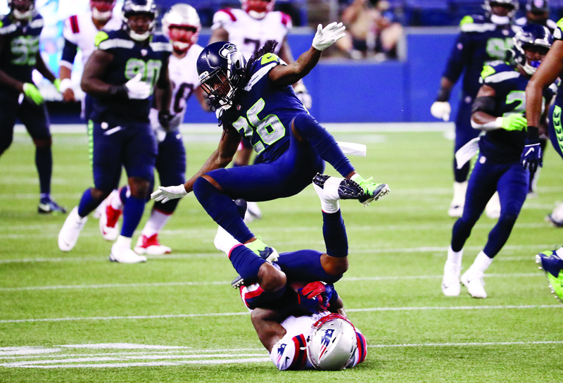SEATTLE, WASHINGTON - SEPTEMBER 20: Shaquill Griffin #26 of the Seattle Seahawks jumps over N'Keal Harry #15 of the New England Patriots during the second half at CenturyLink Field on September 20, 2020 in Seattle, Washington.   Abbie Parr/Getty Images/AFP