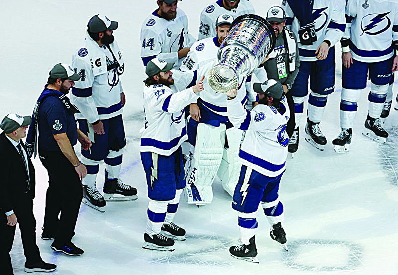 EDMONTON, ALBERTA - SEPTEMBER 28: Tyler Johnson #9 of the Tampa Bay Lightning hands off the Stanley Cup to Brayden Point #21 following the series-winning victory over the Dallas Stars in Game Six of the 2020 NHL Stanley Cup Final at Rogers Place on September 28, 2020 in Edmonton, Alberta, Canada.   Bruce Bennett/Getty Images/AFPn== FOR NEWSPAPERS, INTERNET, TELCOS &amp; TELEVISION USE ONLY ==