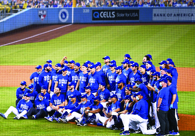 LOS ANGELES, CALIFORNIA - SEPTEMBER 22: The Los Angeles Dodgers pose for a team picture, after a 7-2 win over the Oakland Athletics, to win the National League West Division at Dodger Stadium on September 22, 2020 in Los Angeles, California.   Harry How/Getty Images/AFPn== FOR NEWSPAPERS, INTERNET, TELCOS &amp; TELEVISION USE ONLY ==