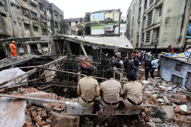 FILE PHOTO: Police officers watch rescue operations after a three-storey building collapsed in Bhiwandi, on the outskirts of Mumbai, India, September, 21 2020. REUTERS/Francis Mascarenhas/File Photo