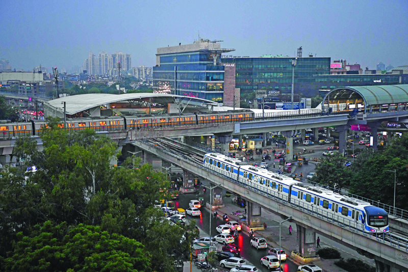 NEW DELHI: A Delhi Metro train (top) and Gurugram Rapid train cross each other at Sikandpur Metro station as Delhi Metro Rail Corporation (DMRC) resumed it services on Yellow line from Samaypur Badli to Huda city centre in Gurugram. - AFP