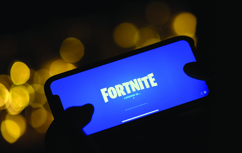 (FILES) In this file photo taken on August 14, 2020 This illustration picture shows a person logging into Epic Games' Fortnite on their smartphone in Los Angeles. - Epic Games will strive anew September 28 to convince a judge that its hit title Fortnite should be restored to Apple's App Store, despite sidestepping the tech titan's standard commission on transactions. (Photo by Chris DELMAS / AFP)