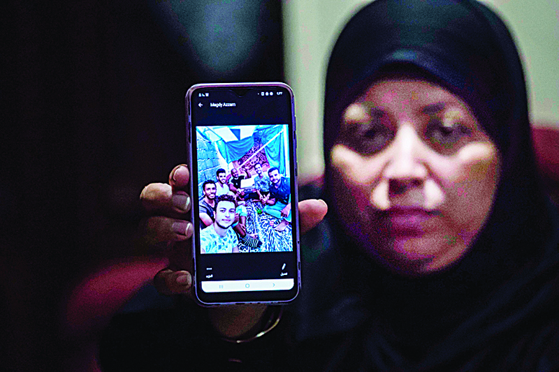 Egyptian Rawya Abdalla shows a phone picture of her relatives, who are among 17 Egyptians that went missing in Libya while trying to get to Europe, during an interview at the Dahmasha village in the Sharkia governorate, 60Km northeast of the capital, on September 23, 2020. - Thousands of desperate migrants bound for Europe have perished in the Mediterranean Sea. In one impoverished Egyptian town, families fear that 15 of their sons are among the dead. (Photo by Khaled DESOUKI / AFP)