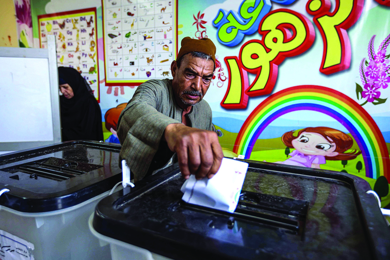 A man casts his ballot at a polling station in El-Ayyat, south of the Egyptian capital on October 24, 2020, during the first stage of the lower house elections. - Polling stations opened in Egypt for parliamentary elections in which there was little doubt of a sweeping victory for supporters of hardline President Abdel Fattah al-Sisi. Some 63 million voters out of Egypt's more than 100 million people are eligible to elect 568 of the 596 lawmakers in the lower house, widely seen as a rubber-stamp body for executive policies. (Photo by Khaled KAMEL / AFP)