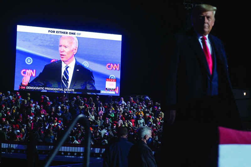 TOPSHOT - US President Donald Trump watches a video of Democratic presidential nominee former Vice President Joe Biden as he holds a Make America Great Again rally as he campaigns at Erie International Airport in Erie, Pennsylvania, October 20, 2020. (Photo by SAUL LOEB / AFP)