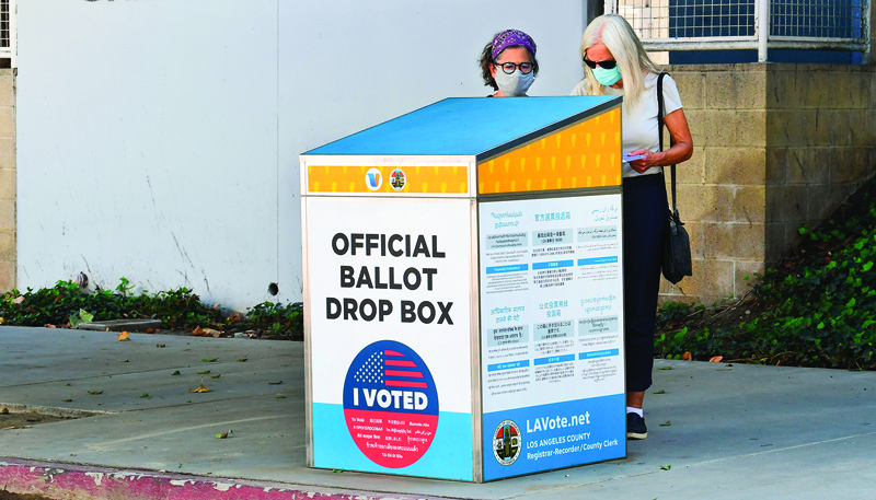 Voters cast their ballots for the 2020 US Elections at an offical ballot drop box on a sidewalk in Los Angeles, California on October 12, 2020, where election officials are looking into the use of unofficial ballot drop boxes installed by California's Republican Party. (Photo by Frederic J. BROWN / AFP)