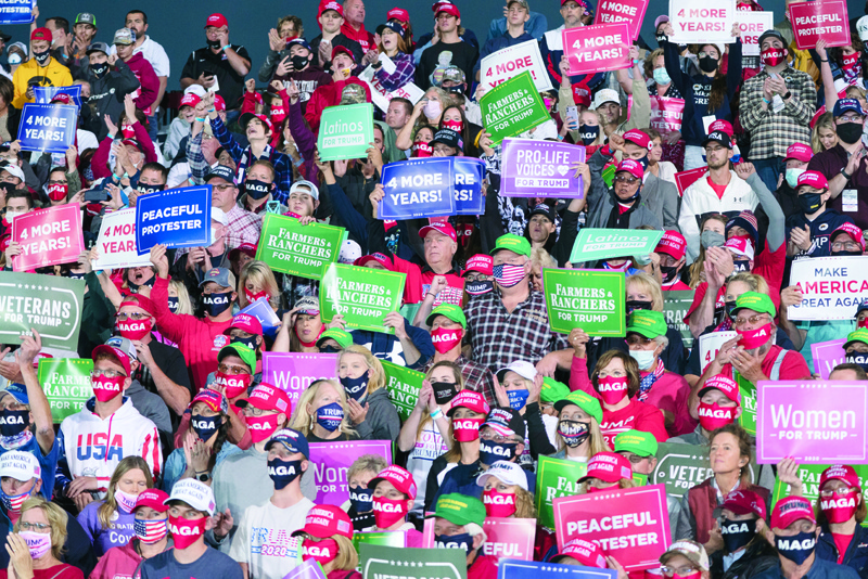 Supporters cheer and hold up signs as the US president speaks at a Make America Great Again campaign event at Des Moines International Airport in Des Moines, Iowa on October 14, 2020. (Photo by Alex Edelman / AFP)