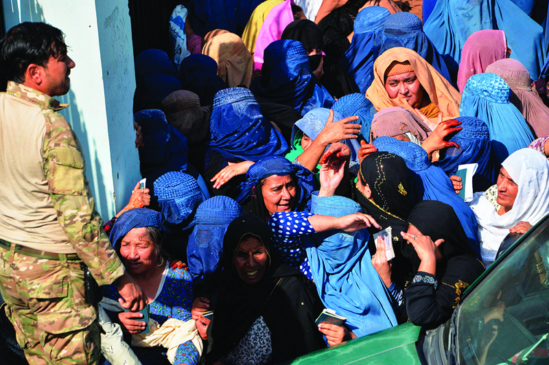 Women gather outside the main entrance gate of a football stadium following a stampede that killed at least 11 women when people were applying for Pakistan visas, in Jalalabad on October 21, 2020. - At least 11 women were killed on October 21 in a stampede in an Afghan football stadium where thousands had gathered to apply for visas at a nearby Pakistan consulate, officials said. (Photo by NOORULLAH SHIRZADA / AFP)