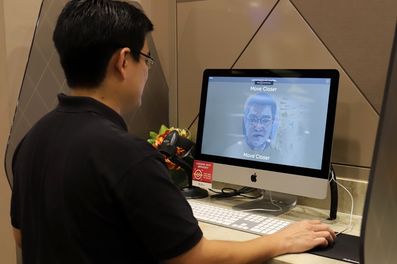 This photo taken on October 1, 2020 shows a staff member of government technology agency GovTech demonstrating the use of facial verification technology to access government services on a computer at a community centre in Singapore. - Singapore will become the world's first country to use facial verification in its national ID scheme, but privacy advocates are alarmed by what they say is an intrusive system vulnerable to abuse. (Photo by MARTIN ABBUGAO / AFP) / TO GO WITH Singapore-biometrics-rights,FOCUS by Martin Abbugao