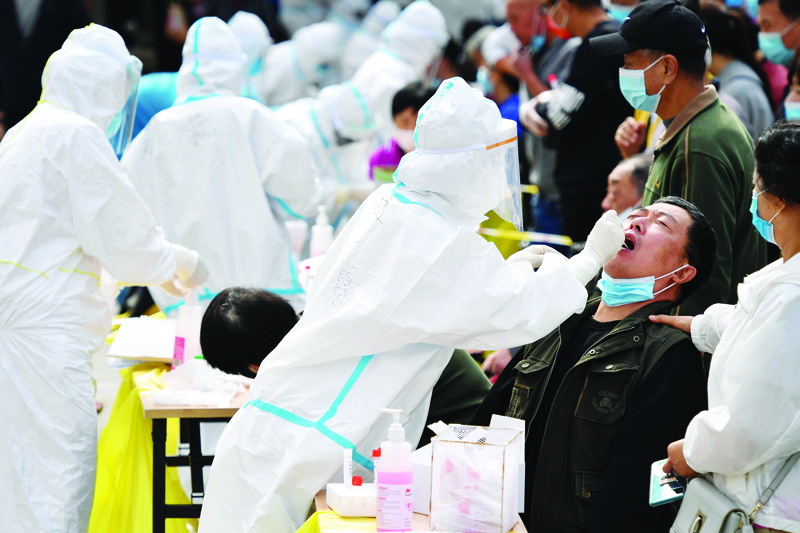 A health worker takes a swab from a resident to be tested for the COVID-19 coronavirus as part of a mass testing program following a new outbreak of the coronavirus in Qingdao, in China's eastern Shandong province on October 13, 2020. (Photo by STR / AFP) / China OUT
