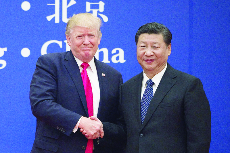 (FILES) This file photo taken on November 9, 2017 shows US President Donald Trump (L) and China's President Xi Jinping shaking hands during a business leaders event at the Great Hall of the People in Beijing. - Donald Trump's first term in office has been rough on China, with war over trade and tech amplified by daily mudslinging, yet Beijing may welcome his re-election as it scans the horizon for the decline of its superpower rival. (Photo by Nicolas ASFOURI / AFP) / TO GO WITH US-vote-diplomacy-trade-China,FOCUS by Patrick Baert