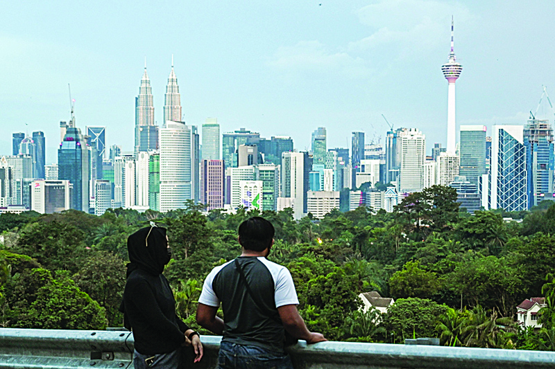 A couple looks at the skyline of Malaysiaís capital Kuala Lumpur on October 25, 2020. (Photo by Mohd RASFAN / AFP)