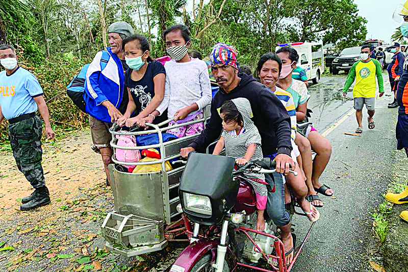 Residents ride on a tricycle back to their homes after tropical storm Molave hit the town of Pola, Oriental Mindoro province on October 26, 2020. (Photo by Erik DE CASTRO / AFP)