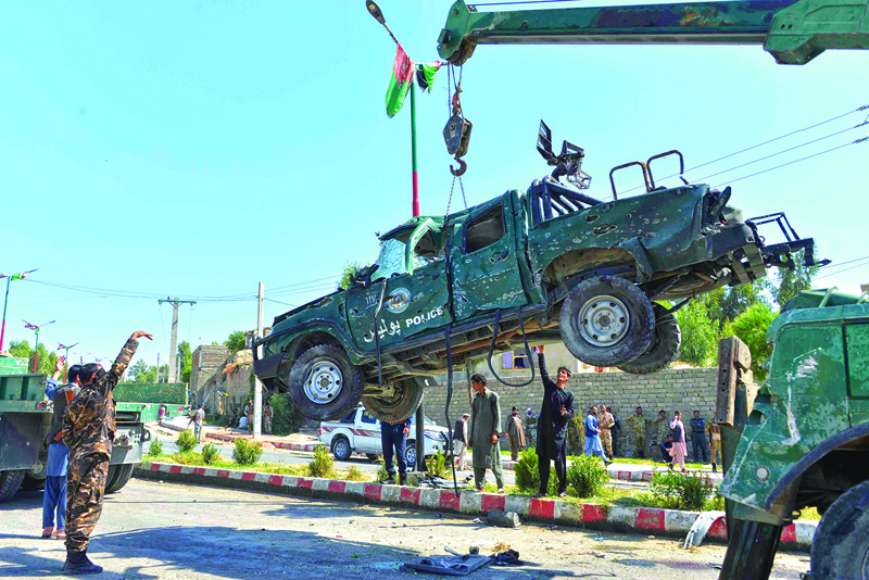 Afghan security forces removes a damaged police vehicle at the site of a car bomb attack that targeted Laghman provincial governor's convoy, in Mihtarlam, Laghman Province on October 5, 2020. - A suicide attack targeting an Afghan provincial governor killed at least eight people on October 5, officials said, as the president travelled to Qatar where peace talks with the Taliban have stalled. (Photo by NOORULLAH SHIRZADA / AFP)