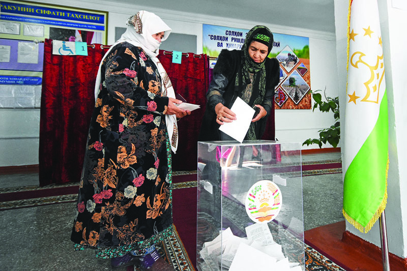 A woman casts her ballot at a polling station during Tajikistan's presidential election in Dushanbe on October 11, 2020, amid the ongoing coronavirus disease pandemic. (Photo by STRINGER / AFP)