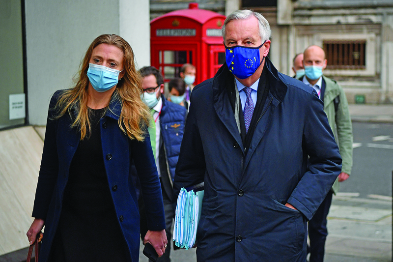 EU chief Brexit negotiator Michel Barnier (R), wearing an EU flag-themed facemask due to the novel coronavirus pandemic, leaves a hotel in London on October 24, 2020 to attend the latest round of Brexit trade talks with the UK. - Britain and the European Union launched an all-out round of Brexit talks vowing to work round the clock to seal a trade deal in the slender time left. (Photo by BEN STANSALL / AFP)