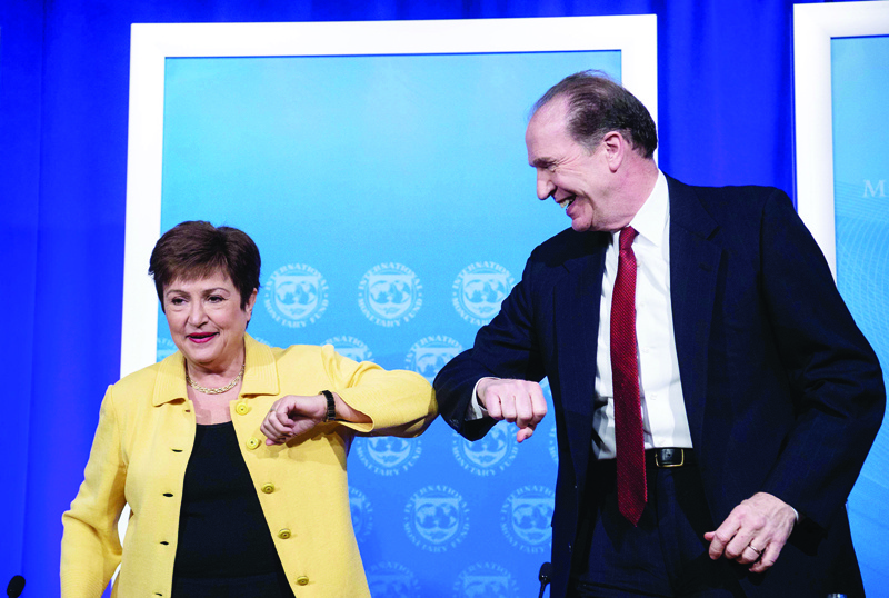 (FILES) In this file photo taken on March 04, 2020, IMF Managing Director Kristalina Georgieva and World Bank Group President David Malpass bump elbows at the end of a joint press briefing on COVID-19 in Washington, DC. - The IMF and World Bank opened their annual meetings on October 14, 2020, with a renewed call for the wealthy to help the poorest deal with the ravages of the coronavirus pandemic, within national borders and globally. The leaders of the IMF and World Bank have been banging the drum about the need to for governments to continue to spend amid the crisis to help support businesses and jobless workers, to keep the emergency from growing far worse. (Photo by NICHOLAS KAMM / AFP)